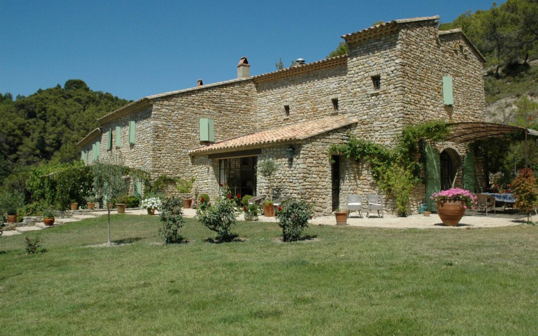 Maison en pierre traditionnelle provençale intégrée dans la nature, symbole d’un habitat durable et aligné.